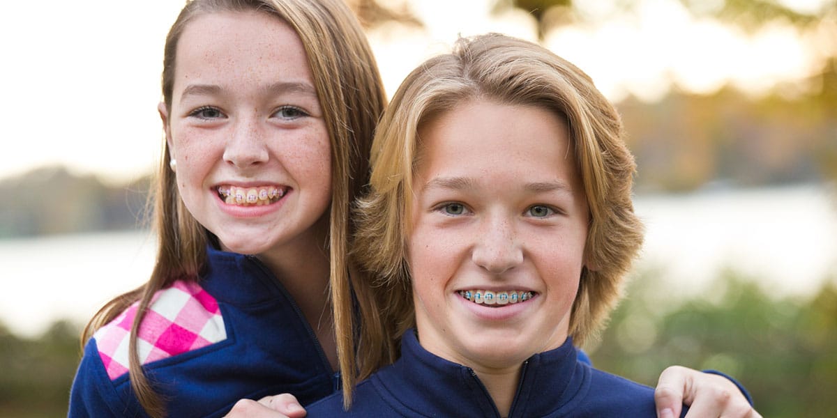 Siblings with braces smiling