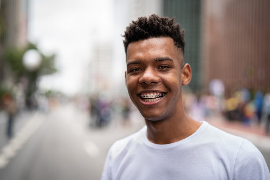 a teenager smiling with braces on his teeth